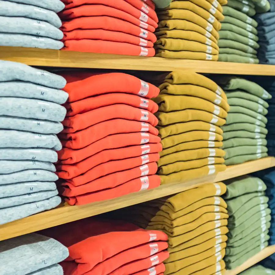 Shelves in a clothing store displaying products of different sizes.